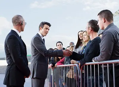 A man shaking hands with another man in front of people.