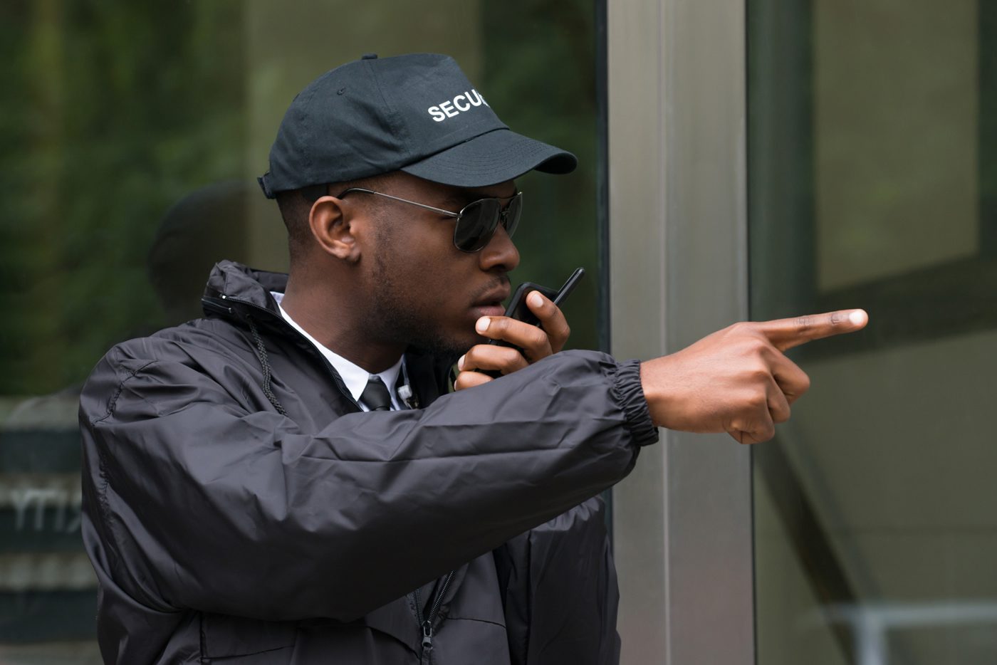 A man in black jacket holding a walkie talkie.